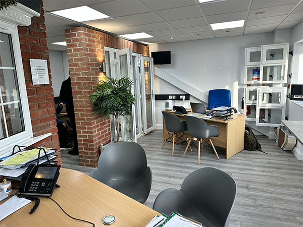 Firmfix showroom showcasing a variety of window and door displays in a modern, spacious setting.